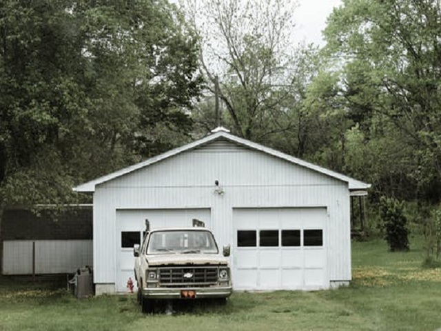 Vit bil framför garage